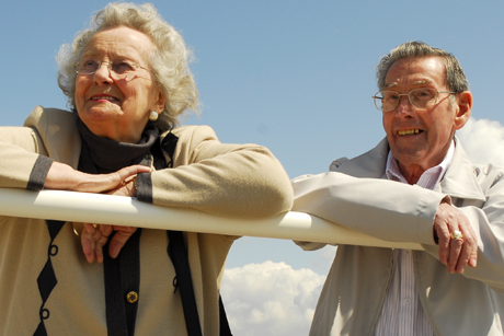Man and woman leaning on railings